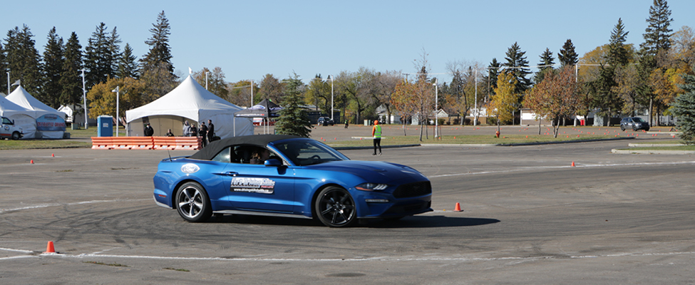 A participant learns about vehicle handling in a Ford Mustang.