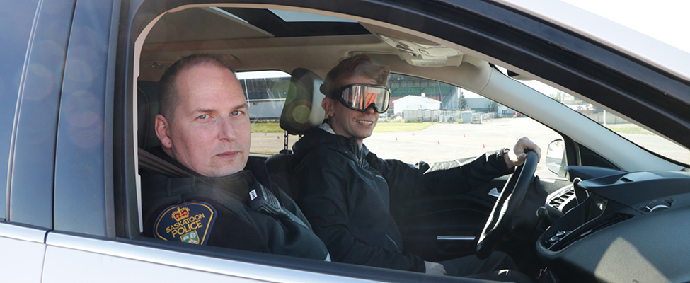 A participant drives with 'fatal vision' goggles with an Saskatoon Police Service member.